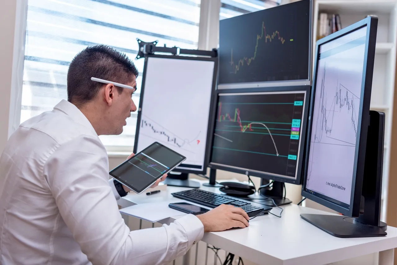 A trader working across multiple monitors