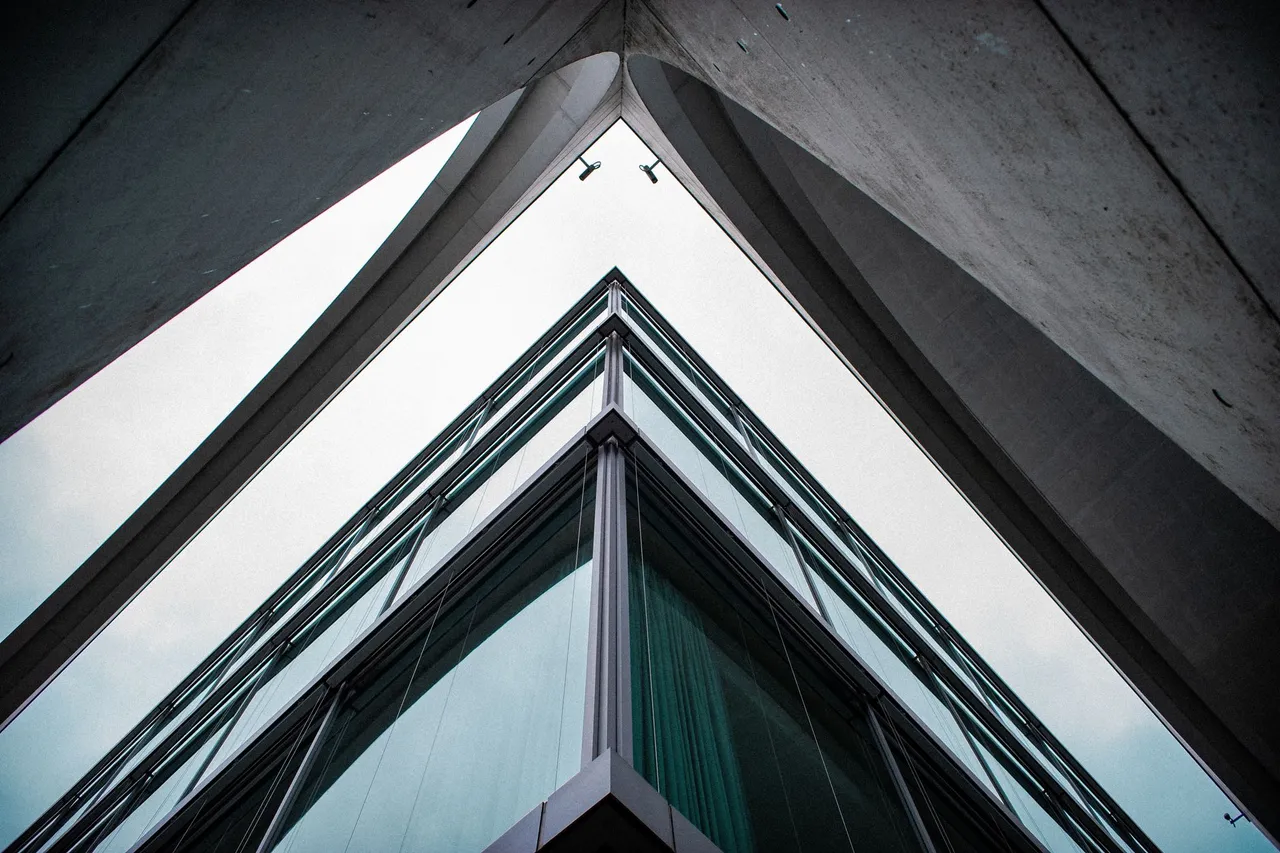 Modern office atrium with glass elevator shaft and gridded skylight ceiling